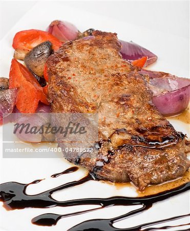 Grilled beef steak with vegetable closeup at plate