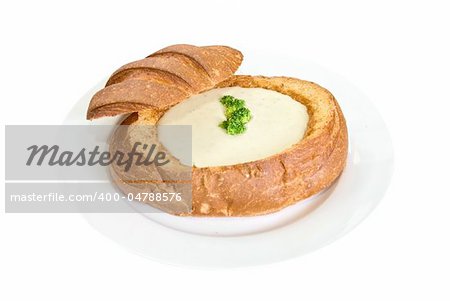 Cheese soup at baked bread as plate on a white background