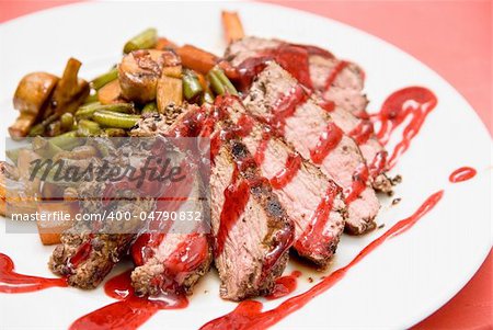 Roasted Beef meat at cranberries sauce with roasted vegetables in cognac