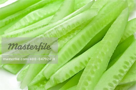 Slices of fresh peeled cucumber over white background