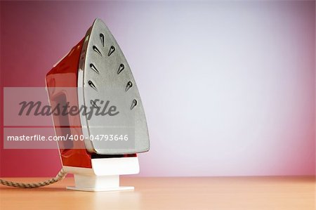 Modern electric iron against the colorful background