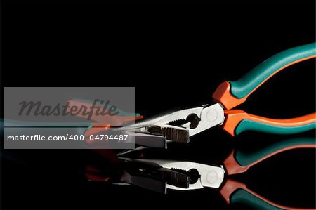locked flat nose and needle nose pliers on black background