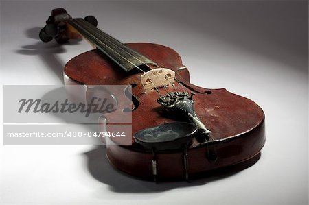 extremely old scratched violin on light background