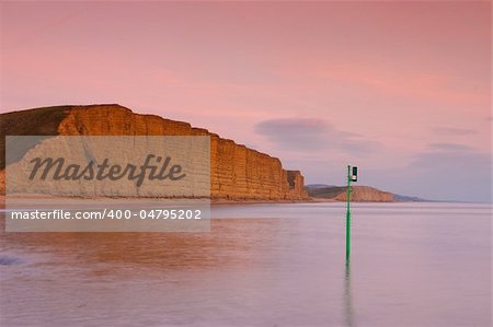 Golden sandstone cliffs at low tide, Burton Bradstock, Dorset, UK