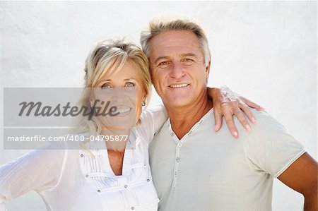 Happy mature couple smiling over white background.