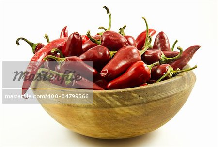 A bunch of peppers in a wooden bowl