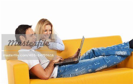 Happy young man and woman sitting together and looking at computer screen