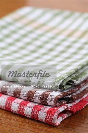 Stack of colorful dish towels on wooden table. Shallow dof