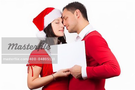 side view of tenderness young couple in red christmas clothes holding a white cardboard in hands
