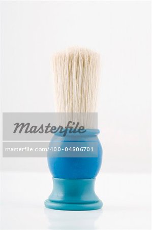 front view of blue shaving brush on white background