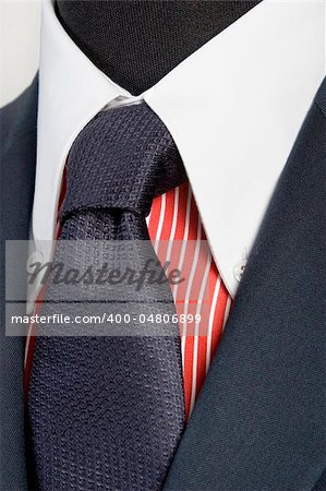 close up of blue suit with tie and red striped shirt