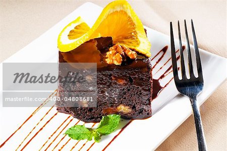 frais cuit délicieux gâteau au chocolat et noix de Grenoble avec tranche d'orance sur une feuille de menthe et de haut