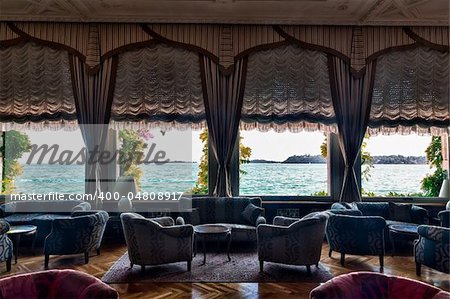 HDR image of luxurious hotel lounge with curtained windows overlooking the lake