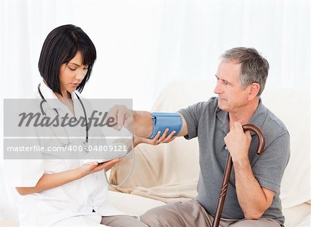 Nurse taking blood pressure of her patient