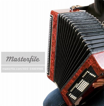 The girl plays an accordion on a white