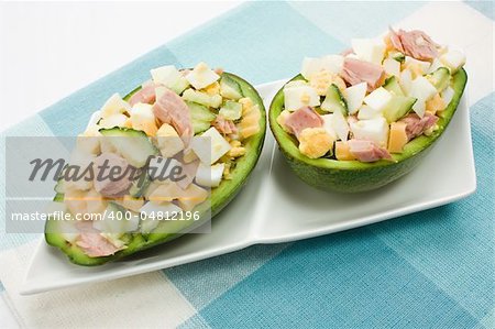 Avocado stuffed with tuna, cucumbers, eggs and cheese