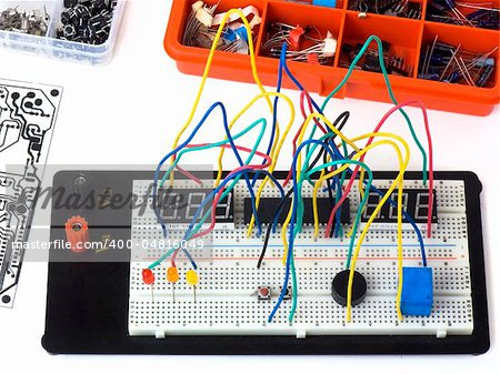 Electronic circuit on a breadboard and electronic components isolated on white background