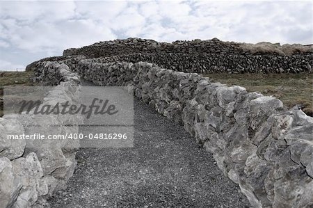 rocky walls and path against a cloudy scenic background in ireland