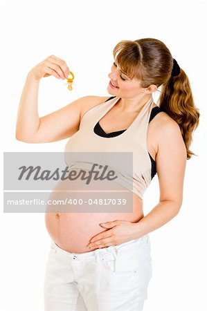 Smiling pregnant woman holding  baby dummy near tummy isolated on white