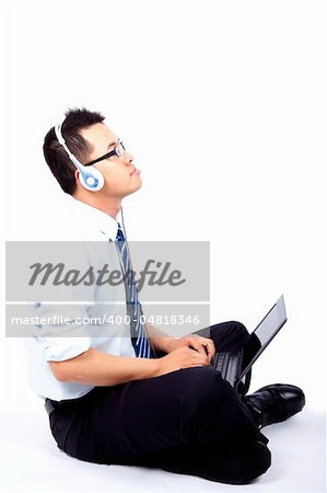 Young man sitting and using a laptop listen to the music
