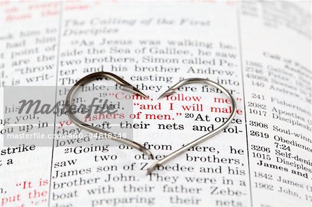 Fishing hook on the Bible with focus on Matthew 4:19 where Jesus calls disciples to be fishers of men