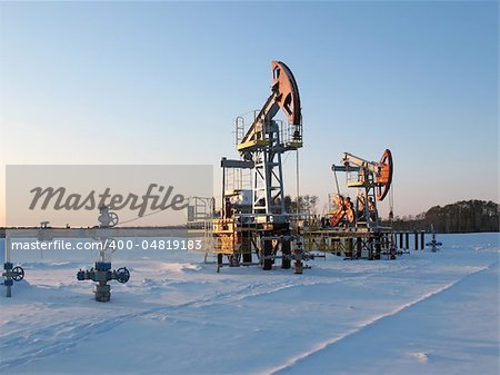 Oil pump jack in work. Oil industry in West Siberia. Siberian frost in sunny day.