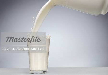 Pouring a glass of milk with splash from jug