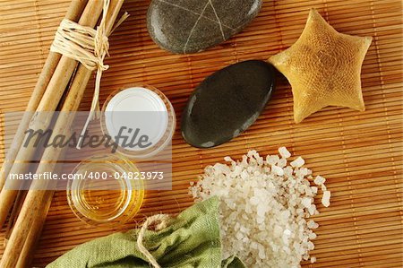 Facilities for body care in a fabric bag of bath salts, related to bamboo sticks, starfish, stones, and two jars of cream and oils