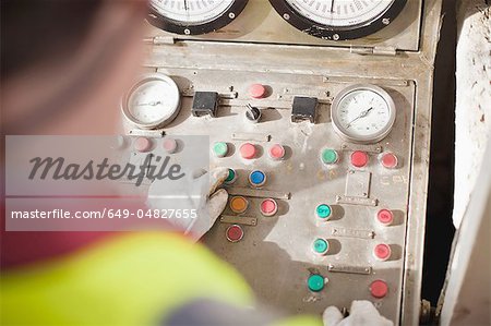 Worker at control panel of oil rig