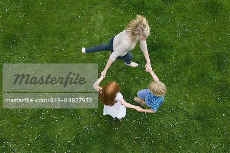 Mother and children playing in grass