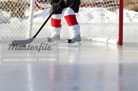 Young child playing outdoor pond ice hockey