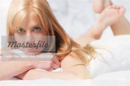 Pretty red haired woman lying in bed