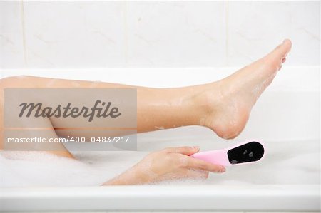 Woman in bath rubbing heel of foot with brush for a pedicure .