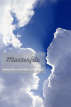 beams from sun in blue sky gray clouds skyscape background