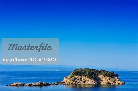 Small island in the Aegean Sea, Greece, under a clear blue sky