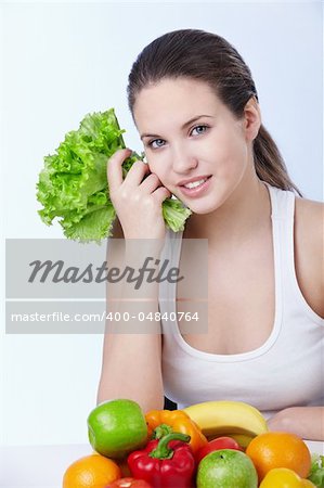 Attractive young girl with fruits and vegetables on white background