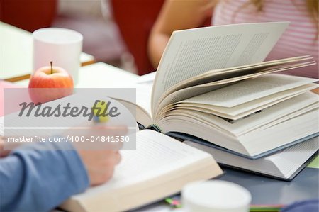 Close-up of two concentrated teenagers studying in the cafeteria of their university