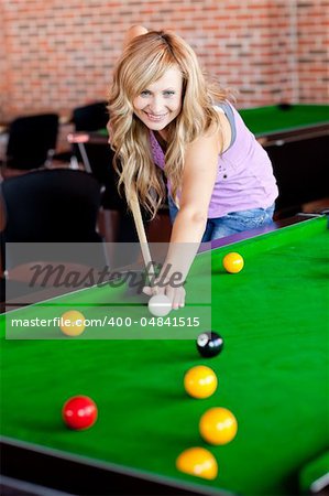 Bright woman playing pool in a club