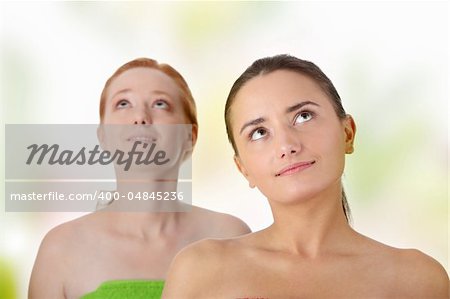 Spa - portrait of two woman - redhead and brunette - looking up