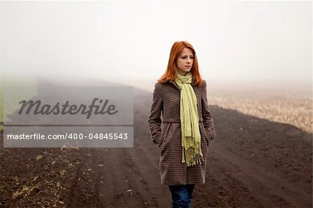 Girl at spring field in fog time.