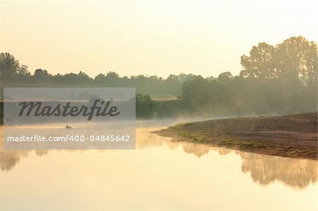 fishing on river in fog - morning landscape