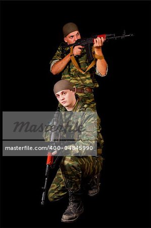 Two soldiers with weapon, isolated on black background