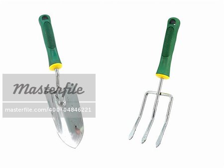 A garden fork and spade isolated against a white background