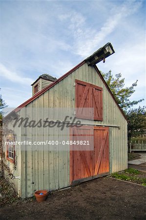 front of a small garden barn against a blue sky