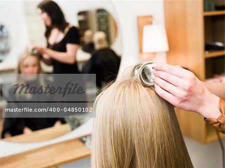 Hairdresser in action with blond customer close up