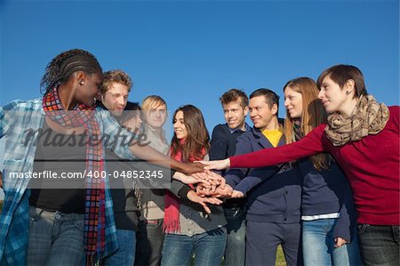 Happy College Students with Hands on Stack