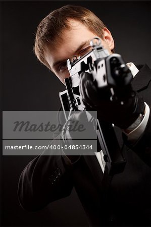 Man with gun over gradient gray. Focused on head