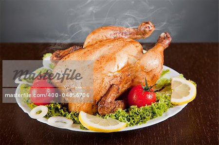 Roast chicken with fresh vegetables, studio shot