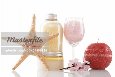 Spa products, candle and cherry flower over white