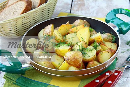 fresh potatoes fried in a pan with dill